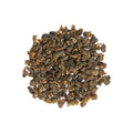 Close-up of Milky Mist Jin Xuan loose leaf tea, tightly rolled oolong tea leaves with a natural green and golden tint.